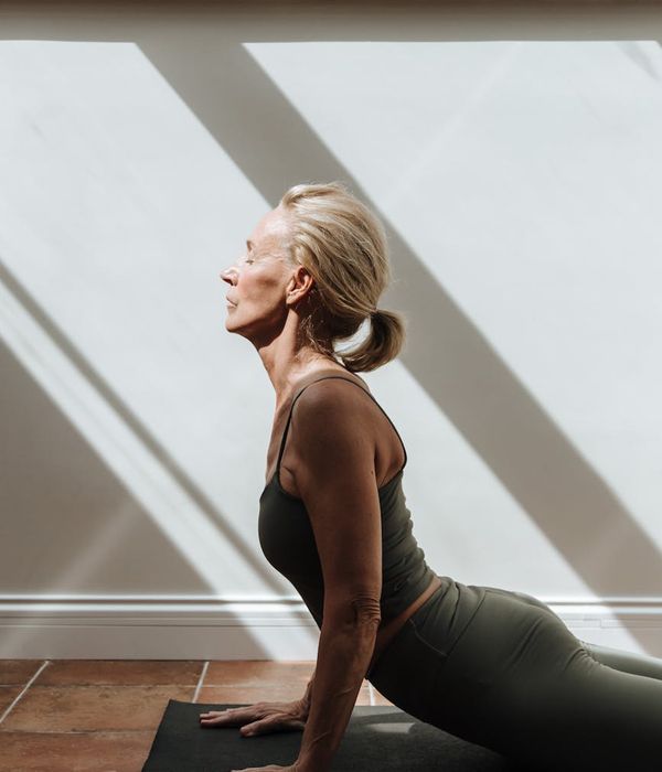 Woman performing a light stretching exercise in a calm environment.